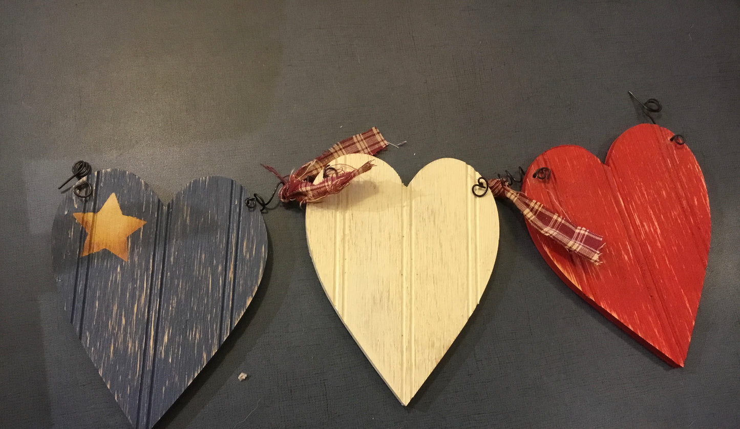 Décoration en bois : 3 coeurs acadiens reliés par du fil